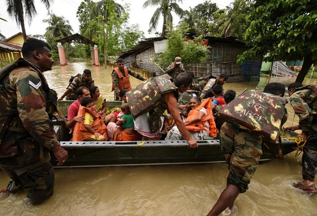 Indian army soldiers evacuate villagers affected by flood in Jakhalabandha area in Nagaon district, in the northeastern state of Assam, India, August 13, 2017. (Photo by Anuwar Hazarika/Reuters)