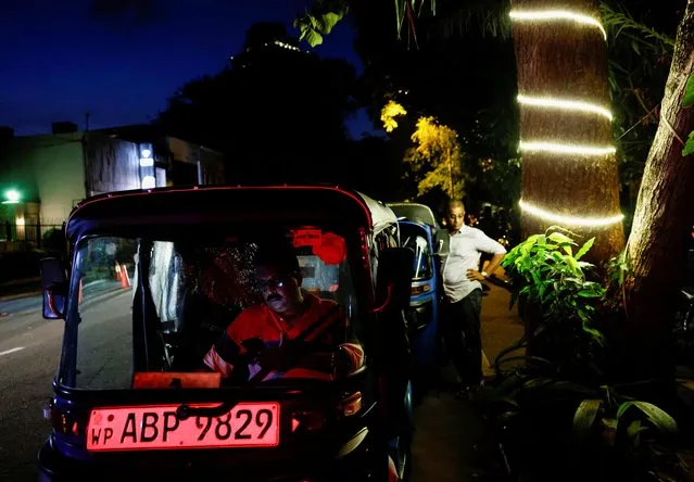 People wait in their three-wheelers in a queue after receiving tokens to buy petrol due to fuel shortage, amid the country's economic crisis, in Colombo, Sri Lanka, June 27, 2022. (Photo by Dinuka Liyanawatte/Reuters)