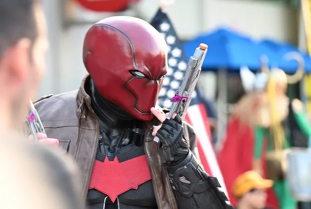 A cosplayer dressed as Red Hood from Batman, walks outside the convention center during Comic-Con International 2022 on July 21, 2022 in San Diego, California. (Photo by Robyn Beck/AFP Photo)