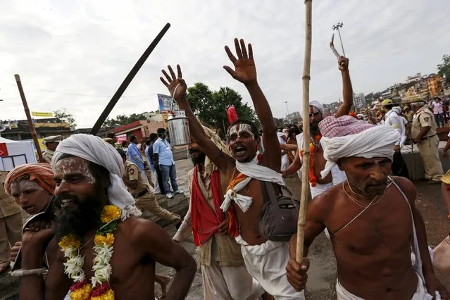 Sadhus or Hindu holy men shout religious hymns as they arrive to take a dip in the Godavari river during the first Shahi Snan (grand bath) at Kumbh Mela, or Pitcher Festival in Nashik, India, August 29, 2015. (Photo by Danish Siddiqui/Reuters)