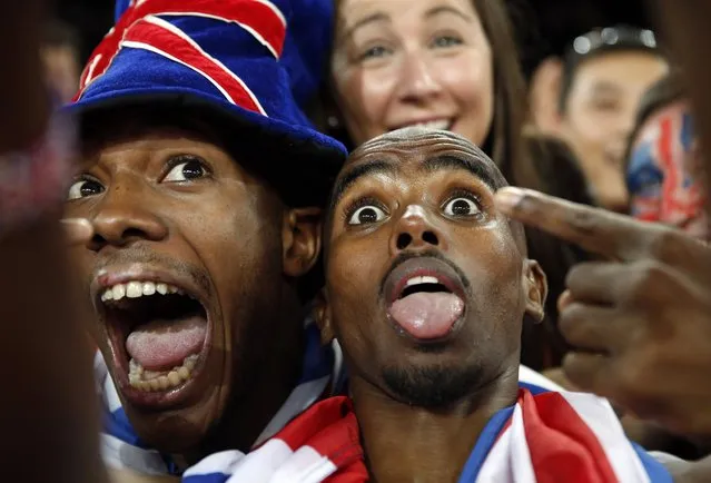 Britain's Mo Farah has a selfie taken with spectators as he celebrates after winning the gold medal in the men's 5000m final at the  World Athletics Championships at the Bird's Nest stadium in Beijing, Saturday, August 29, 2015. (Photo by Ng Han Guan/AP Photo)