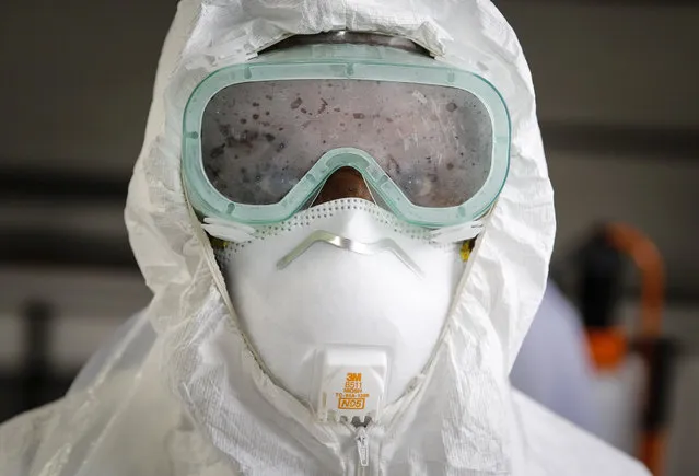 A doctor practices how to use protective equipment before heading to a ward at Mbagathi hospital for patients under quarantine and confirmed cases with the new coronavirus, at Kenyatta National Hospital in Nairobi, Kenya Thursday, April 2, 2020. (Photo by Brian Inganga/AP Photo)