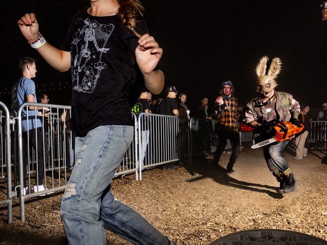 A scare actor chases a guest with a chainsaw at Fear Farm in Glendale, AZ on October 6th, 2023. (Photo by Cassidy Araiza for The Washington Post)