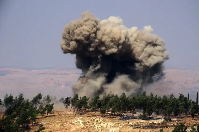 Smoke billows at the site of a reported Russian strike in a forest area west of in Syria's rebel-held northwestern city of Idlib, on August 22, 2022. (Photo by Muhammad Haj Kadour/AFP Photo)