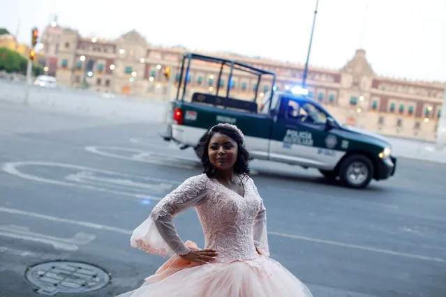 A girl poses for her quinceañera (15th birthday) pictures in Zocalo Square amid the outbreak of the coronavirus disease (COVID-19), in Mexico City, Mexico on April 15, 2020. (Photo by Gustavo Graf/Reuters)