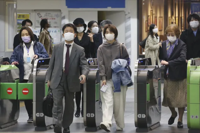 People wearing face masks to protect against the spread of the new coronavirus pass the gates at Yokohama station, near Tokyo, Wednesday, April 15, 2020. (Photo by Koji Sasahara/AP Photo)