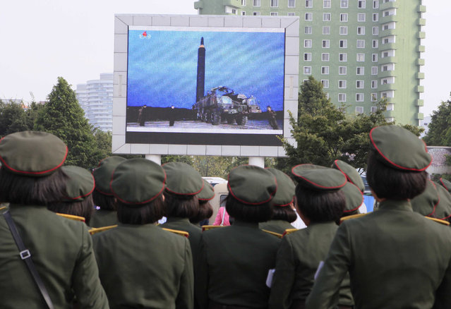 People fill the square of the main railway station to watch a televised news broadcast of the test-fire of an inter-continental ballistic rocket Hwasong-12, Wednesday, August 30, 2017, in Pyongyang, North Korea. By firing a missile over Japan and putting the Asia-Pacific, including U.S. territory Guam, on notice for more and more ambitious tests, the North has won itself greater space for more weapons tests Washington and Seoul see as provocative. (Photo by Kim Kwang Hyon/AP Photo)