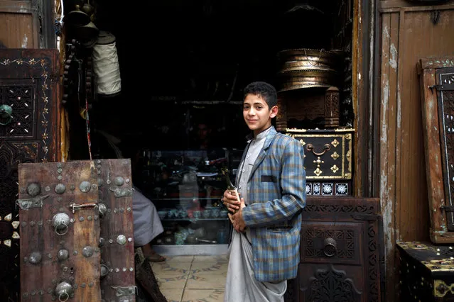 A young man smiles as he comes out of a traditional gift shop at the old quarter of the city of Sanaa, Yemen, July 24, 2016. (Photo by Mohamed al-Sayaghi/Reuters)