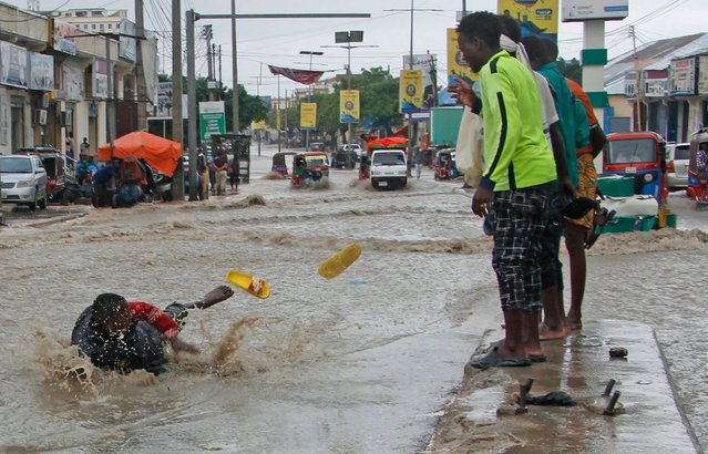 A man slips in flood water after heavy rainfall, in Mogadishu Somalia, Monday, November 20, 2023. (Photo by Farah Abdi Warsameh/AP Photo)