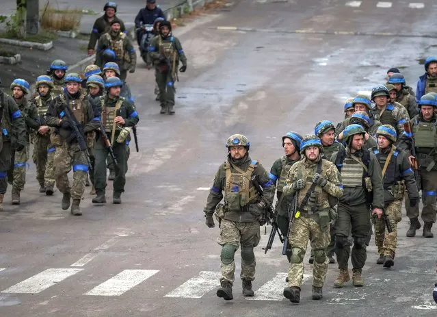 Ukrainian servicemen walk, as Russia's attack on Ukraine continues, in the town of Izium, recently liberated by Ukrainian Armed Forces, in Kharkiv region, Ukraine on September 14, 2022. (Photo by Gleb Garanich/Reuters)