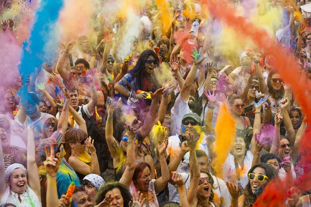 Revelers of the Holi Festival of Colors throw colored powders in the air in Madrid, Spain, Saturday, August 9, 2014. The festival is fashioned after the Hindu spring festival Holi, which is mainly celebrated in the north and east areas of India. (Photo by Daniel Ochoa de Olza/AP Photo)