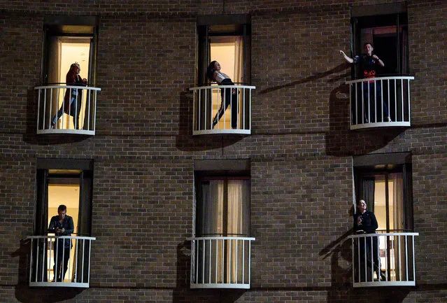 Hotel guests in quarantine, a mandatory protocol for travellers returning to Australia to curb the spread of the coronavirus disease (COVID-19), watch a musical performance from their rooms in Sydney, Australia, May 18, 2020. Picture taken May 18, 2020. (Photo by James Gourley/AAP Image via Reuters)