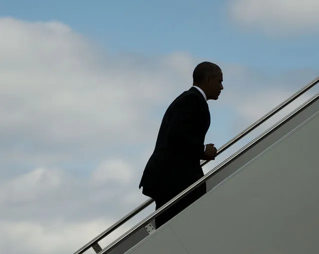 President Barack Obama is seen silhouetted as he walks up the stairs to board Air Force One, Tuesday, September 16, 2014, at Andrews Air Force Base, Md. Obama is traveling to the Centers for Disease Control and Prevention in Atlanta, to address the Ebola crisis and announce a plan to help the West Africa nations fight the spread of the Ebola virus. (Photo by Pablo Martinez Monsivais/AP Photo)