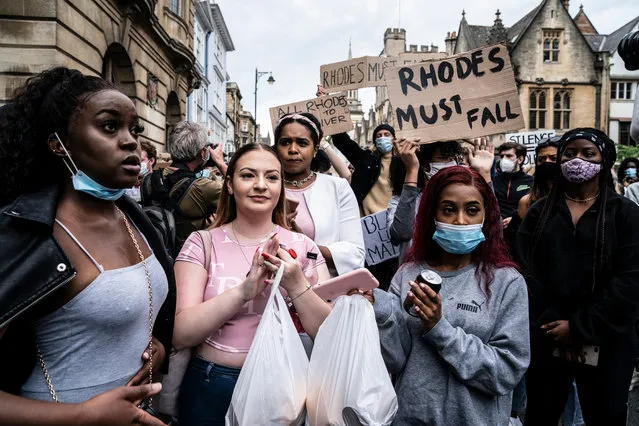 Protestors carry placards during a demonstration called by the Rhodes Must Fall campaign calling for the removal of the statue of British imperialist Cecil John Rhodes outside Oriel Cllege, at the University of Oxford on June 9, 2020. Following the toppling of slave trader Edward Colston during a Black Lives Matter protest in Bristol on June 6, the Rhodes Must Fall campaign has called for a protest action outside Oriel College, University of Oxford where a statue of imperialist Cecil John Rhodes is mounted on the wall. (Photo by Sean Smith/The Guardian/The Guardian)
