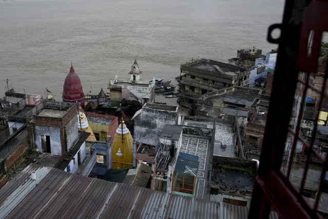In this Friday, August 26, 2016 photo, the Manikarnika Ghat, center, is submerged by the flood waters in Varanasi, India. As the mighty Ganges River overflowed its banks this past week following heavy monsoon rains, large parts of the Hindu holy town of Varanasi were submerged by floodwaters, keeping away thousands of Hindu devotees. Varanasi is a pilgrim town that Hindus visit to take a dip in the holy Ganges. (Photo by Tsering Topgyal/AP Photo)