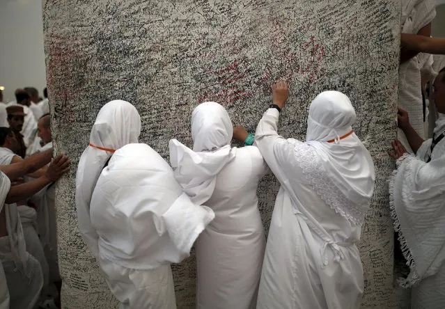 Muslim pilgrims touch a rock atop Mount Mercy on the plains of Arafat during the annual haj pilgrimage, outside the holy city of Mecca September 22, 2015. (Photo by Ahmad Masood/Reuters)