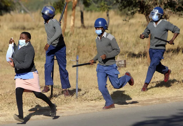 Riot police give chase a nurse who was protesting at a government hospital in Harare, Monday, July, 6, 2020. Thousands of nurses working in public hospitals stopped reporting for work in mid-June, part of frequent work stoppages by health workers who earn less than $50 a month and allege they are forced to work without adequate protective equipment. On Monday, dozens of nurses wearing masks and their white and blue uniforms gathered for protests at some of the country’s biggest hospitals in the capital, Harare, and the second-largest city of Bulawayo. (Photo by Tsvangirayi Mukwazhi/AP Photo)