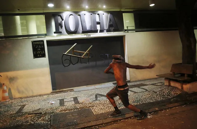A demonstrator attacks the Folha de S. Paulo newspaper office during a protest against Brazil's new President Michel Temer after Brazil's Senate removed former President Dilma Rousseff in Sao Paulo, Brazil, August 31, 2016. (Photo by Nacho Doce/Reuters)
