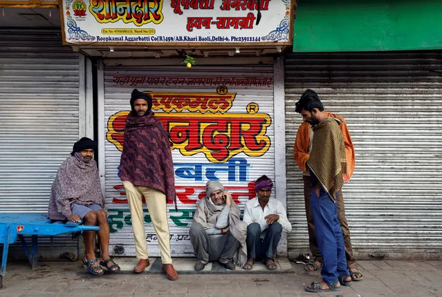 Labourers stand as they wait for work at a market on a cold morning in the old quarters of Delhi, November 27, 2017. (Photo by Saumya Khandelwal/Reuters)