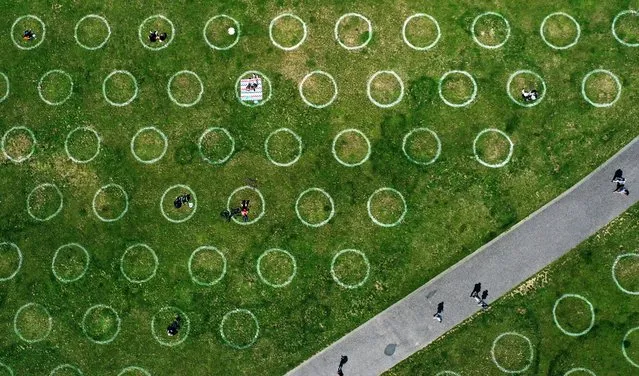 An aerial view shows a field with painted circles for social distance at the Rhine promenade in Duesseldorf, western Germany on July 12, 2020. (Photo by Ina Fassbender/AFP Photo)