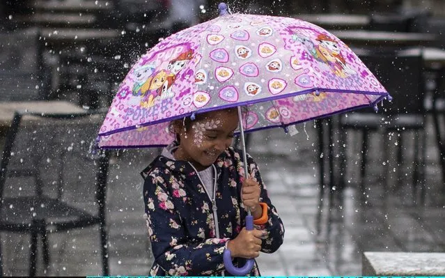A girl stands in the pouring rain near the London Eye on August 14, 2019 in London, England. (Photo by Dan Kitwood/Getty Images)