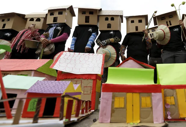 Cambodian protesters and rights activists gather in front of the National Assembly building with mock cardboard houses to mark the 30th World Habitat Day in Phnom Penh on October 5, 2015. The protesters used the day to call on the government to stop forced evictions across the country. (Photo by Tang Chhin Sothy/AFP Photo)