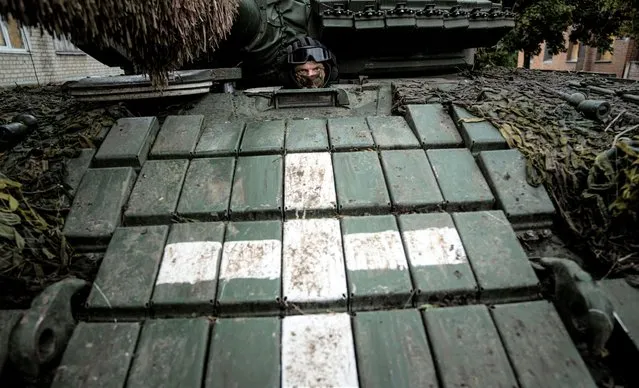 A Ukrainian serviceman sits in a tank, in the recently retaken area of Izium, Ukraine, Wednesday, September 14, 2022. (Photo by Evgeniy Maloletka/AP Photo)