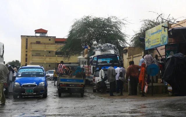 People are seen boarding various transport vehicles in the rain in Al Fashir, capital of North Darfur September 5, 2016. (Photo by Mohamed Nureldin Abdallah/Reuters)