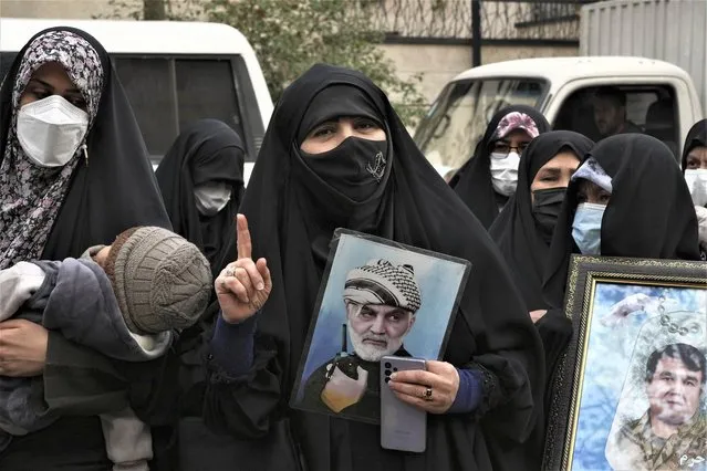 An Iranian woman holds a portrait of the late Revolutionary Guard Gen. Qassem Soleimani, who was killed in Iraq in a U.S. drone attack in 2020, in a pro-government demonstration in front of the United Nation's office in Tehran, Iran, Tuesday, December 13, 2022. The demonstrators condemned calls for the Islamic Republic to be expelled from the UN Commission on the Status of Women by other member countries, following Iranian security forces' continued crackdown on anti-government protests sparked by the death of a women after she was arrested by the country's morality police in September. (Photo by Vahid Salemi/AP Photo)