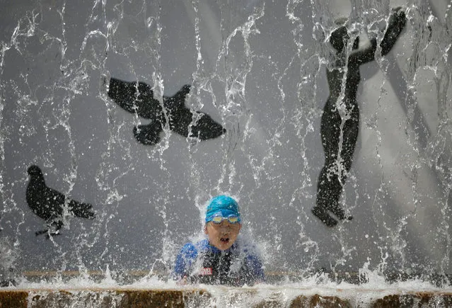 A child cools off under a public fountain, amid the coronavirus disease (COVID-19) outbreak, during hot summer weather at a park in Tokyo, Japan on August 13, 2020. (Photo by Issei Kato/Reuters)