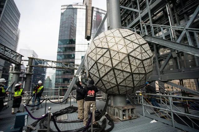 Workers install sparkling new Waterford Crystal triangles featuring this year's “Gift of Love” design on the Times Square New Year's Eve Ball on the roof of One Times Square in Manhattan, New York City, U.S., December 27, 2022. (Photo by Eduardo Munoz/Reuters)