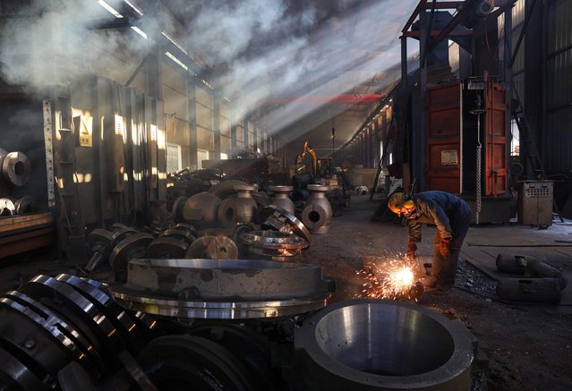 A worker polishes machinery at a workshop of a steel machinery factory in Hangzhou, in eastern China's Zhejiang province on June 6, 2025. (Photo by AFP Photo/China Stringer Network)