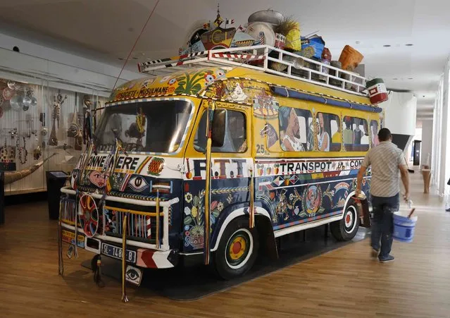 A worker walks past a renovated traditional public transport bus from Dakar, Senegal, 1960, during a press visit as preparations continue at the Museum of Mankind (Musee de l'Homme) in Paris, France, October 14, 2015. (Photo by Jacky Naegelen/Reuters)