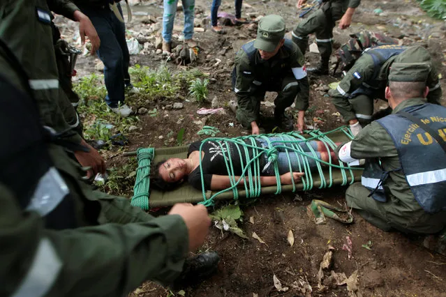 Nicaraguan army members prepare to carry a participant playing the role of a victim during a national multi-hazard drill organized by the National System for Prevention, Mitigation and Attention to Disasters (SINAPRED), in the 30 de Mayo neighborhood in Managua, Nicaragua, September 26, 2016. (Photo by Oswaldo Rivas/Reuters)