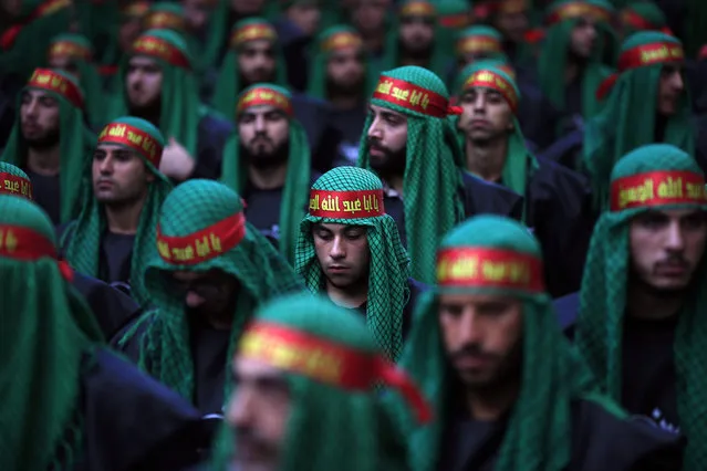 Lebanese Shiite supporters of Hezbollah listen to the story of Imam Hussein, during activities marking the holy day of Ashoura, in southern Beirut, Lebanon, Saturday, October 24, 2015. Ashoura is the annual Shiite Muslim commemoration marking the death of Imam Hussein, the grandson of the Prophet Muhammad, at the Battle of Karbala in present-day Iraq in the 7th century. Arabic writing on bandanas reads, "Oh Abu-Abdullah Hussein". (Photo by Hassan Ammar/AP Photo)