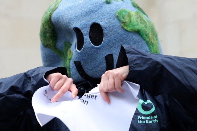 An environmental campaigner tears a piece of paper that says “Carbon budget delivery plan” outside the High Court in London, Britain on May 3, 2024. London's High Court has ruled that Britain's latest climate action plan is unlawful, in a legal challenge brought by Friends of the Earth, ClientEarth and the Good Law Project over Britain's new climate action plan. (Photo by Hollie Adams/Reuters)
