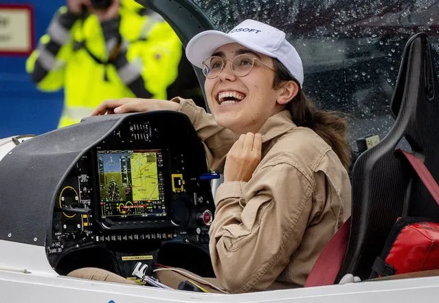 Belgium-British teenage pilot Zara Rutherford smiles after she landed with her Shark ultralight plane at the Egelsbach airport in Frankfurt, Germany, Wednesday, January 19, 2022. At the age of 19, she is set to land her single-seater Shark sport aircraft in Kortrijk, Belgium, on Monday, more than 150 days after setting out to become the youngest woman to circumnavigate the world solo. American aviator Shaesta Waiz was 30 when she set the previous benchmark. (Photo by Michael Probst/AP Photo)