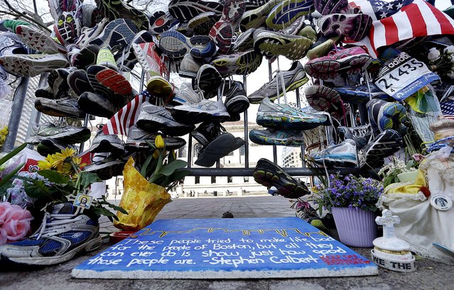 Running shoes hang on a fence at a makeshift memorial near the Boston Marathon finish line in Copley Square, in remembrance of the Boston Marathon bombings, on April 25, 2013. (Photo by Elise Amendola/Associated Press)