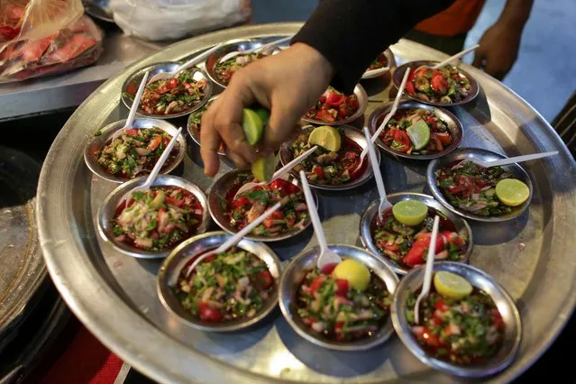 A worker arranges salads at a street restaurant for the Egyptian traditional food “Suhoor” which is a staple during the holy month of Ramadan in Cairo, Egypt on April 11, 2023. (Photo by Hadeer Mahmoud/Reuters)