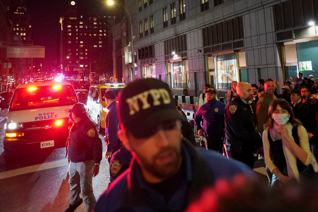 Police officers operate as people gather outside 26 Federal Plaza (Jacob K. Javits Federal Building), where migrants who were detained during a raid in Lower Manhattan by U.S. Immigration and Customs Enforcement (ICE) were brought in, in Manhattan, New York, U.S., October 21, 2025. (Photo by David Dee Delgado/Reuters)