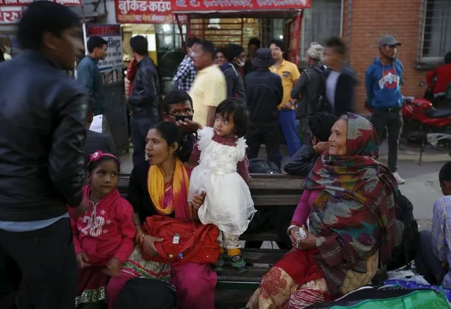 A family waits for a bus to head towards their village to celebrate "Dashain", the biggest religious festival for Hindus in Nepal, as fuel crisis continues in Kathmandu, October 19, 2015. Many people who live in Nepal's capital hail from districts outside the Kathmandu Valley and return home for the festival. (Photo by Navesh Chitrakar/Reuters)