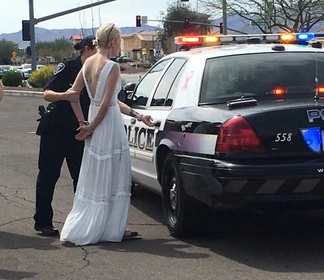 A police officer arrests a bride-to-be for driving while impaired to her wedding, after responding to a three-car collision in Marana, Arizona, U.S. in a photo released March 12, 2018. (Photo by Reuters/Marana Police Department)