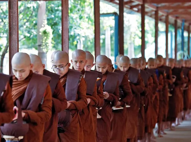 Buddhist novices line up for lunch alms at a monastery on the eve of the Full Moon Day of Tabaung celebrations, in Yangon, Myanmar, 04 March 2023. Full Moon Day of Tabaung, which in 2023 falls on 05 March, marks the last month of Myanmar's lunar calendar. People traditionally make donations to monks and build stupas or pagodas with sand along the beach. (Photo by Nyein Chan Naing/EPA)