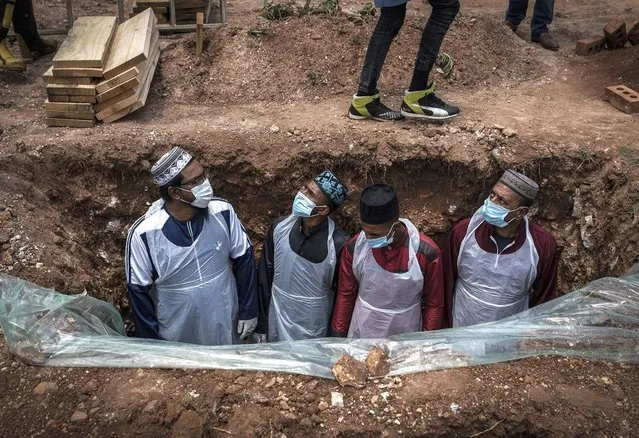 Members of the Saaberie Chishty Burial Society prepare the grave for the burial of a person who died from COVID-19 at the Avalon Cemetery in Lenasia, Johannesburg Saturday December 26, 2020. South Africa’s health minister has announced an “alarming rate of spread” in the country, with more than 14,000 new confirmed coronavirus cases and more than 400 deaths reported Wednesday. It was the largest single-day increase in cases. (Photo by Shiraaz Mohamed/AP Photo)