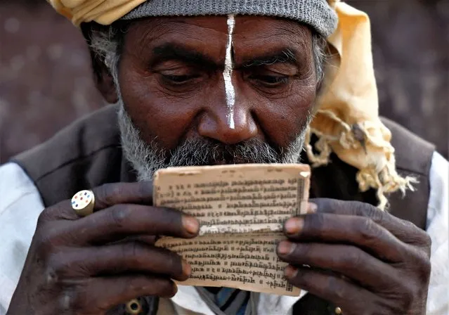 A Hindu holy man, or sadhu, reads a holy book at the premises of Pashupatinath Temple during the Shivaratri festival in Kathmandu, Nepal on February 18, 2023. (Photo by Navesh Chitrakar/Reuters)