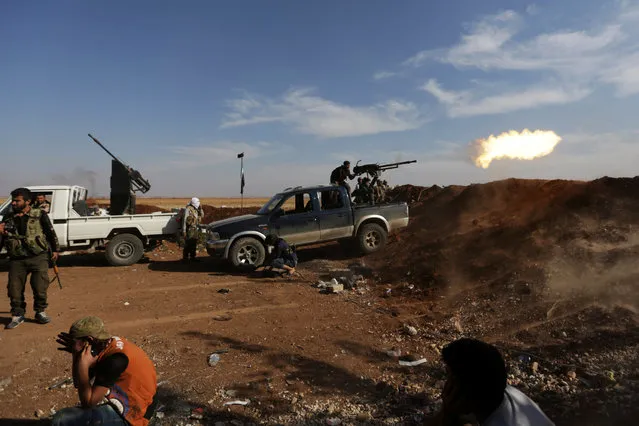 Rebel fighters in Marea city shoot a weapon towards Syria Democratic Forces (SDF) controlled Tell Rifaat town, northern Aleppo province, Syria October 21, 2016. (Photo by Khalil Ashawi/Reuters)