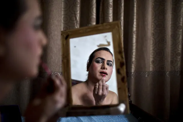 Pakistani Waseem Akram, 27, applies makeup on his face as he prepares himself for a party at a friend's place in Rawalpindi, Pakistan, January 10, 2015. (Photo by Muhammed Muheisen/AP Photo)
