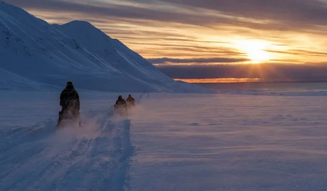 Scientists drive their snowmobiles cross the arctic towards Kongsfjord during sunset near Ny-Alesund, Svalbard, Norway on April 10, 2023. (Photo by Lisi Niesner/Reuters)