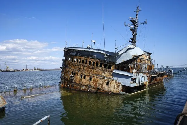 A partially sunken Ukrainian warship sits in the water in an area of the Mariupol Sea Port in Mariupol, in territory under the government of the Donetsk People's Republic, eastern Ukraine, Friday, April 29, 2022. This photo was taken during a trip organized by the Russian Ministry of Defense. (Photo by AP Photo/Stringer)