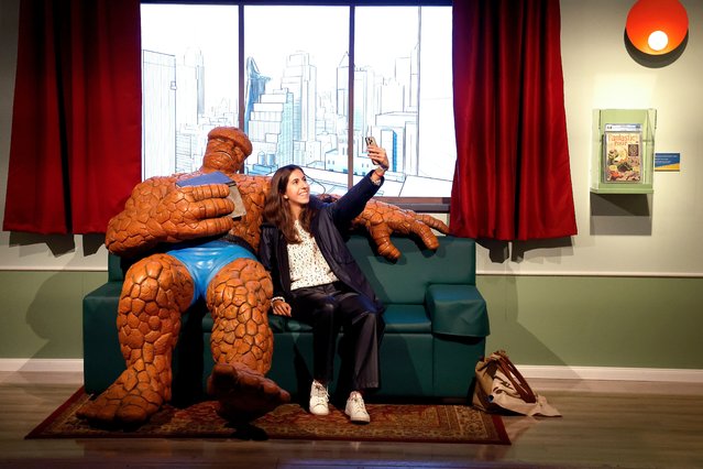 A woman poses with “The Thing” character's sculpture as she visits “Marvel: Universe of Super Heroes” exhibition, during its presentation on the eve of its opening at IFEMA Convention and Congress Center in Madrid, Spain, 14 November 2024. (Photo by J. P. Gandul/EPA/EFE)